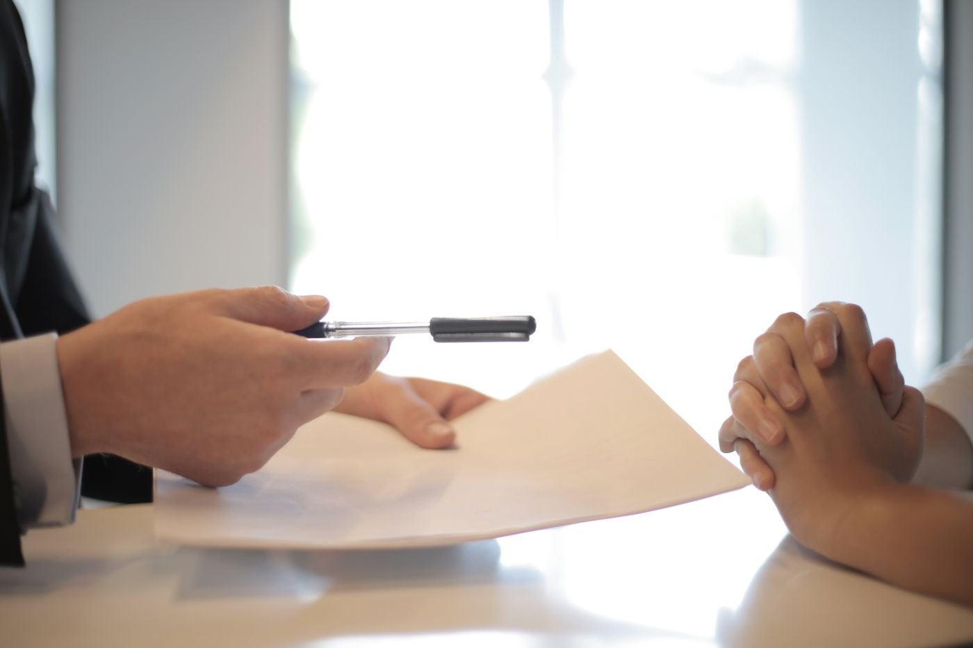 A policy document being handed across a desk